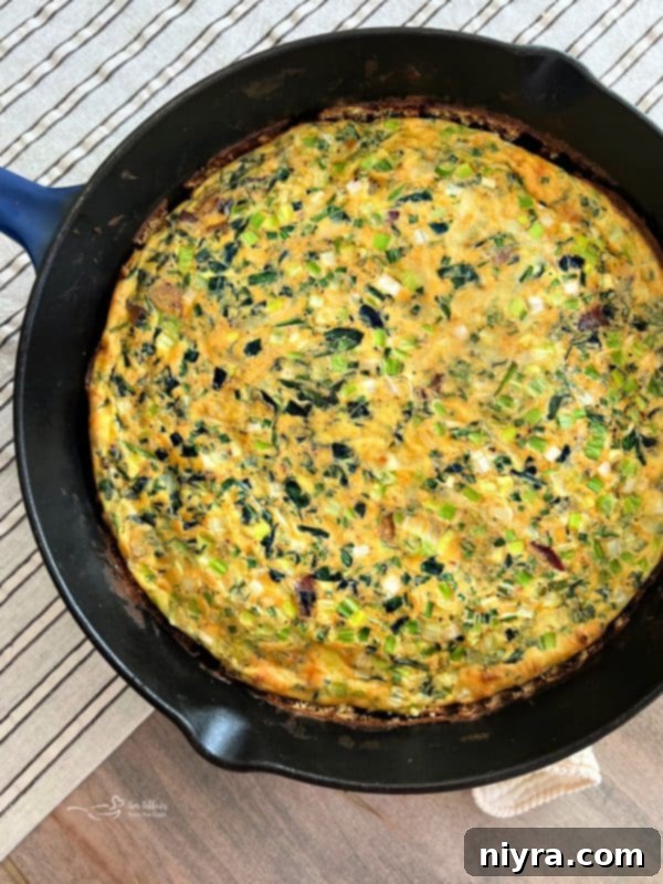 Egg mixture poured over vegetables in skillet, cooking on stove