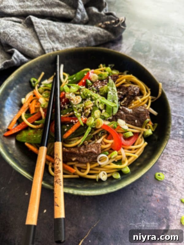 Beef Lo Mein in a bowl with chopsticks.