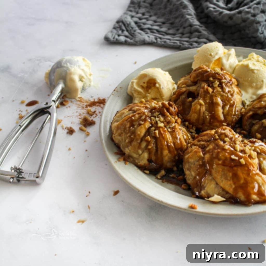 Spiced Rum Caramel Apple Dumplings 3 Serving of apple dumpling with ice cream and rum caramel sauce