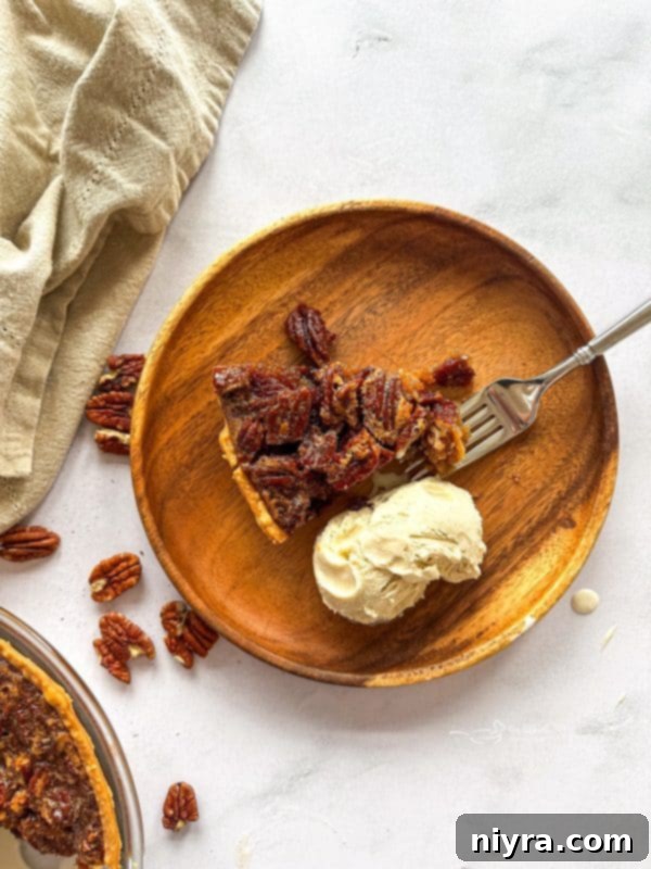 Slice of Pecan Pie with a golden crust and rich, nutty filling, served on a plate.