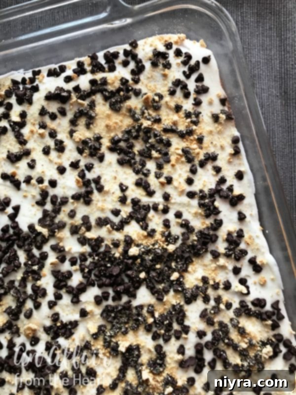 S'mores Brownies 8 Thick layer of homemade marshmallow buttercream frosting being spread over cooled S'mores Brownies