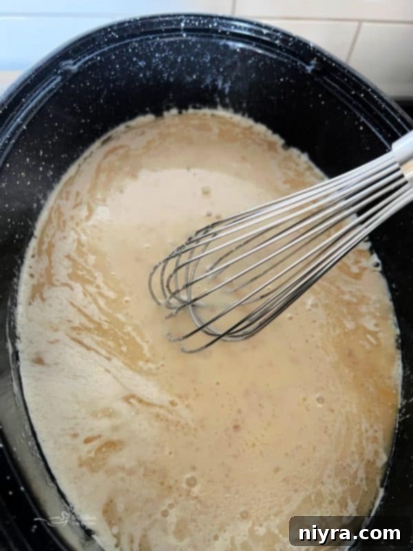 Step 6: Whisking the gravy mixture on the stovetop until fully incorporated and smooth.