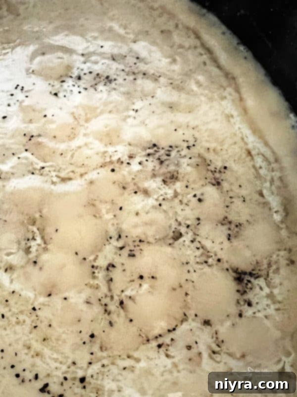 Step 7: The finished, thickened homemade pork gravy simmering gently on the stove.