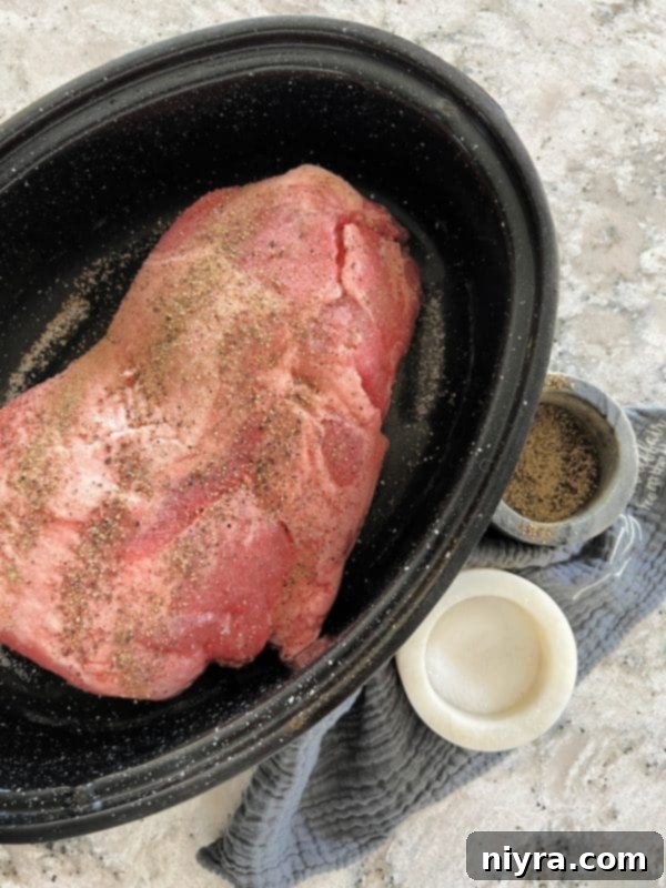 Step 1: Seasoning the pork roast generously with salt and pepper in a roasting pan.