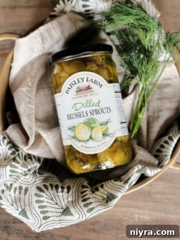 Close-up of a jar of Paisley Farm Dilled Brussels Sprouts with a few sprouts scattered around
