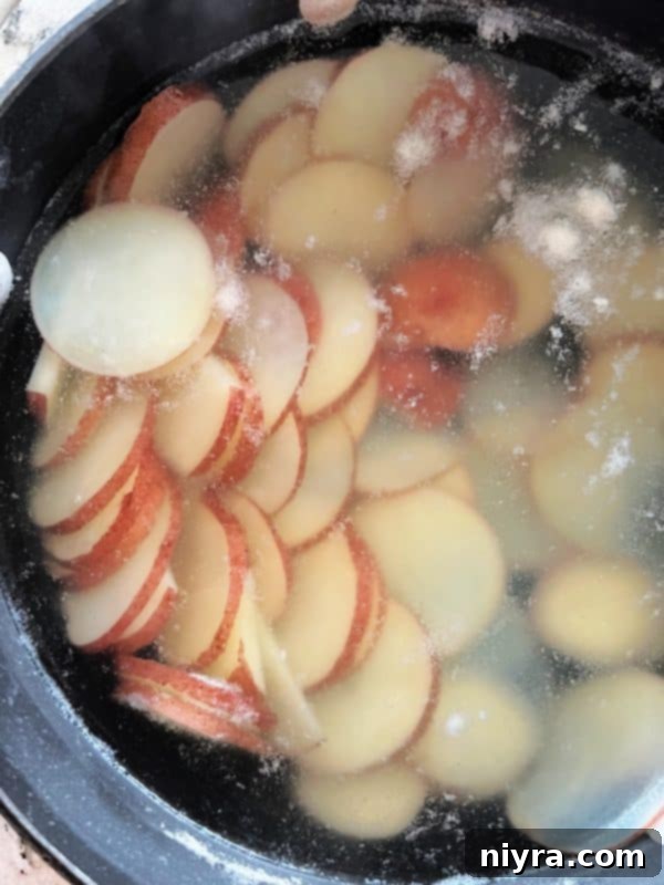 Sliced red potatoes boiling in a pot of water