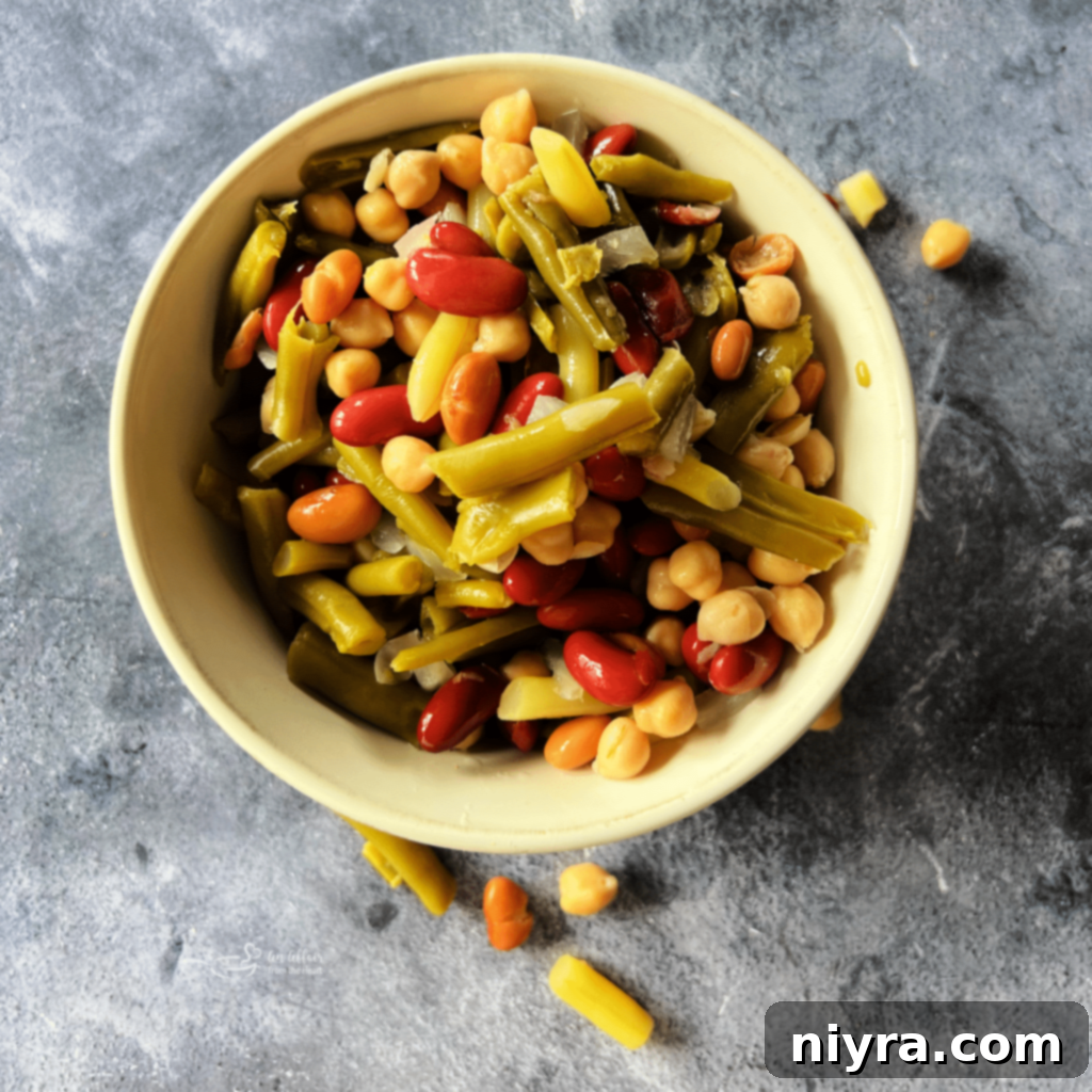 Jar of Paisley Farm Five Bean Salad next to fresh ingredients.