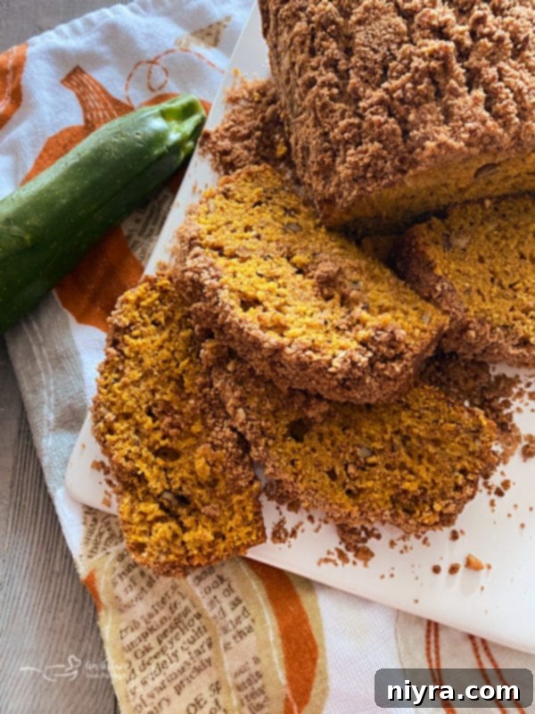 Pumpkin Zucchini Crumble Loaf 18 Pumpkin Zucchini Streusel Bread sliced on a wooden board