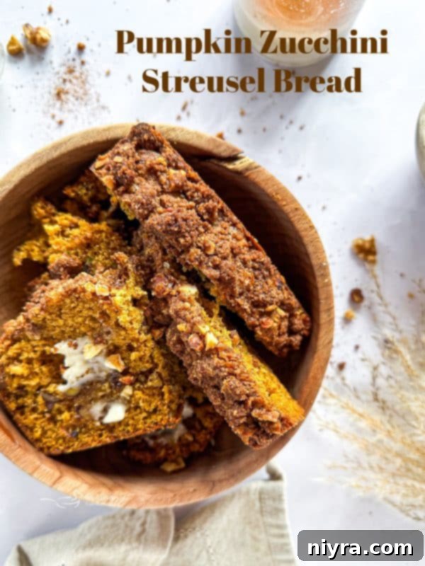 Pumpkin Zucchini Crumble Loaf 20 A whole loaf of Pumpkin Zucchini Streusel Bread on a wooden board