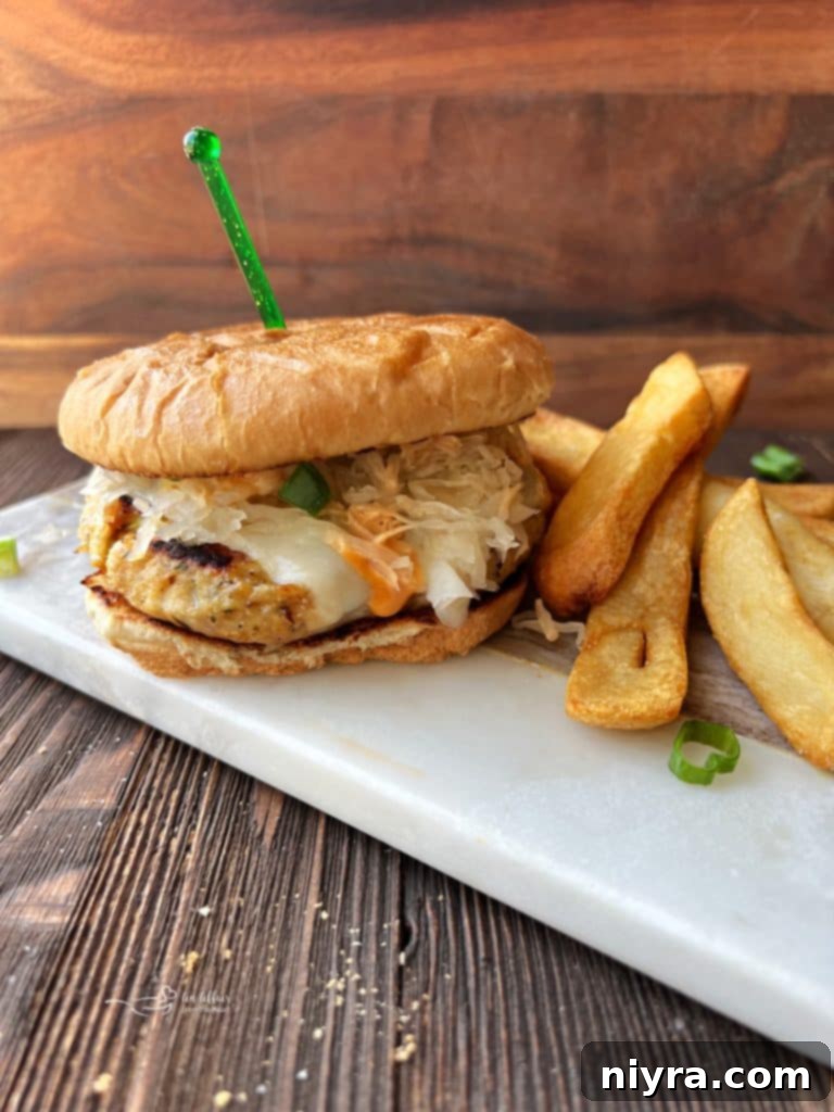 A perfectly assembled Turkey Reuben Burger with a side of crispy fries.