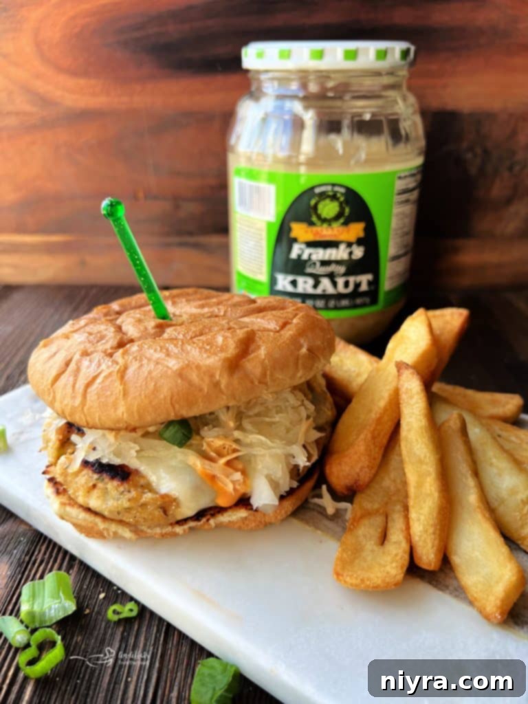 Two vibrant Turkey Reuben Burgers with melted cheese and kraut, ready to be served.