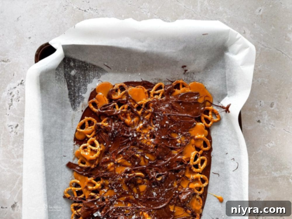 Salted Caramel Chocolate Pretzel Bars 11 Step 6: Sprinkling coarse sea salt over the chocolate and caramel layers.