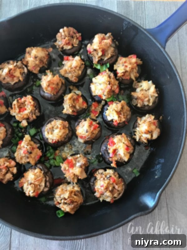 Stuffed mushrooms arranged in a cast iron skillet, ready for baking