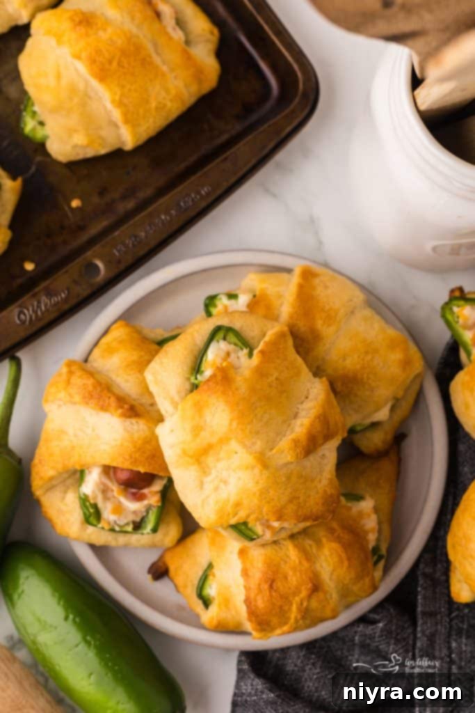 Close-up of baked Jalapeño Popper Pigs in a Blanket showcasing the golden crust and filling