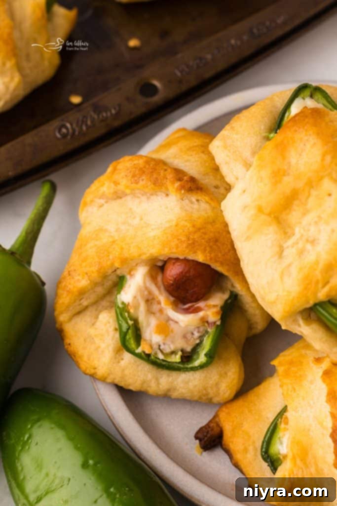 Final presentation of Jalapeño Popper Pigs in a Blanket on a rustic serving board