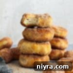 Easy Air Fryer Biscuit Donuts 17 Close up of Air Fryer Biscuit Donuts stacked on a counter.