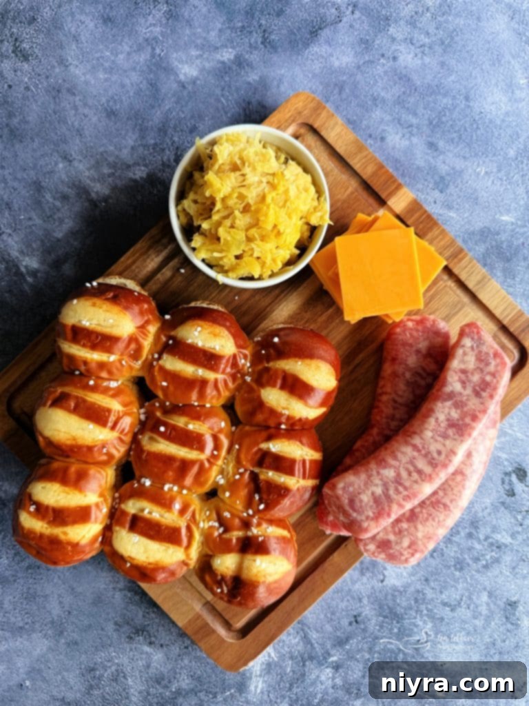 Cooked brat patties and mustard kraut arranged on pretzel bun bottoms.
