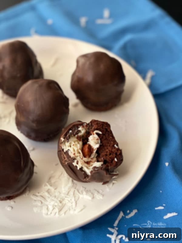 A close-up of several Almond Joy Brownie Bites, showing their glossy chocolate coating.