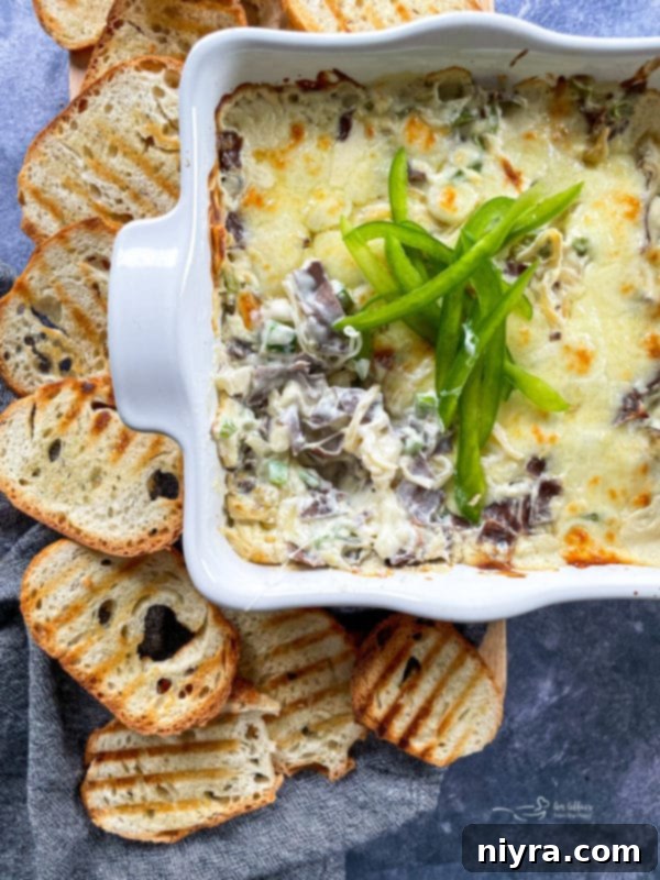 Philly Cheese Steak Dip baked in a dish with green peppers