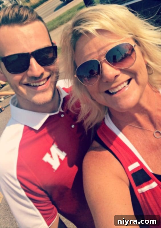 Michaela and her son in red shirts at a football game