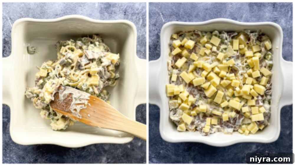 Philly Cheese Steak Dip mixture spread into a baking dish with a wooden spoon