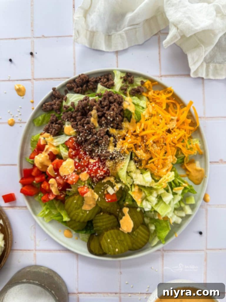 A vibrant Big Mac Salad with seasoned beef, crisp lettuce, cheese, pickles, and special sauce in a large bowl.