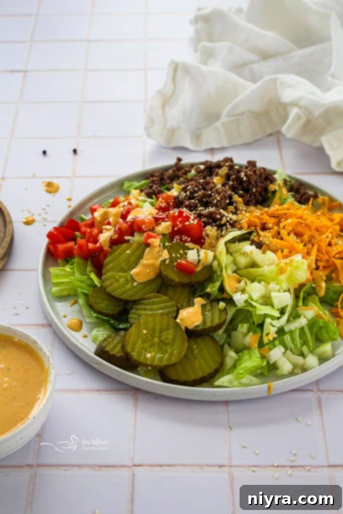 Big Mac Salad in a white bowl with a fork, ready to be eaten.
