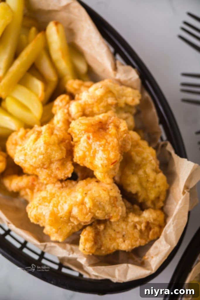 Fiery Honey Crispy Chicken Bites 2 Crispy Hot Honey Popcorn Chicken in a basket with fries.