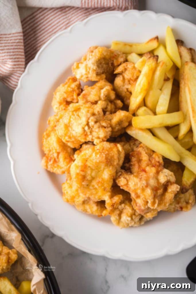 Fiery Honey Crispy Chicken Bites 3 Plate of Hot Honey Popcorn Chicken with a side of dipping sauce.