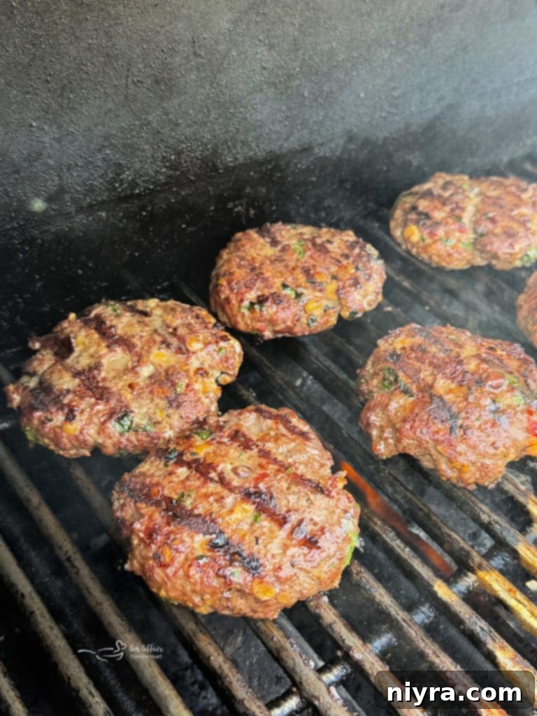 Mexican burger patties grilling on a barbecue.