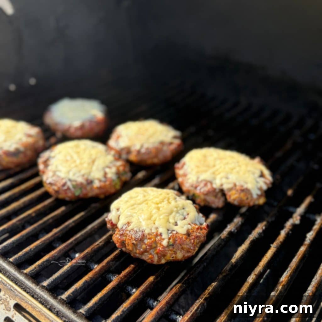 Mexican burgers on the grill with cheese melting.