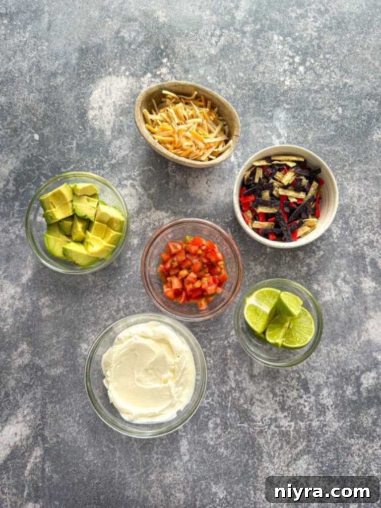 Ingredients for black bean soup laid out on a kitchen counter, including fresh vegetables, canned beans, and spices.