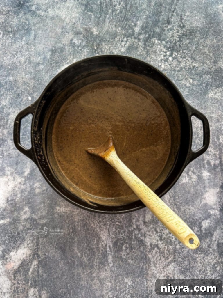 A pot of black bean soup before blending, showing the whole beans and vegetables.