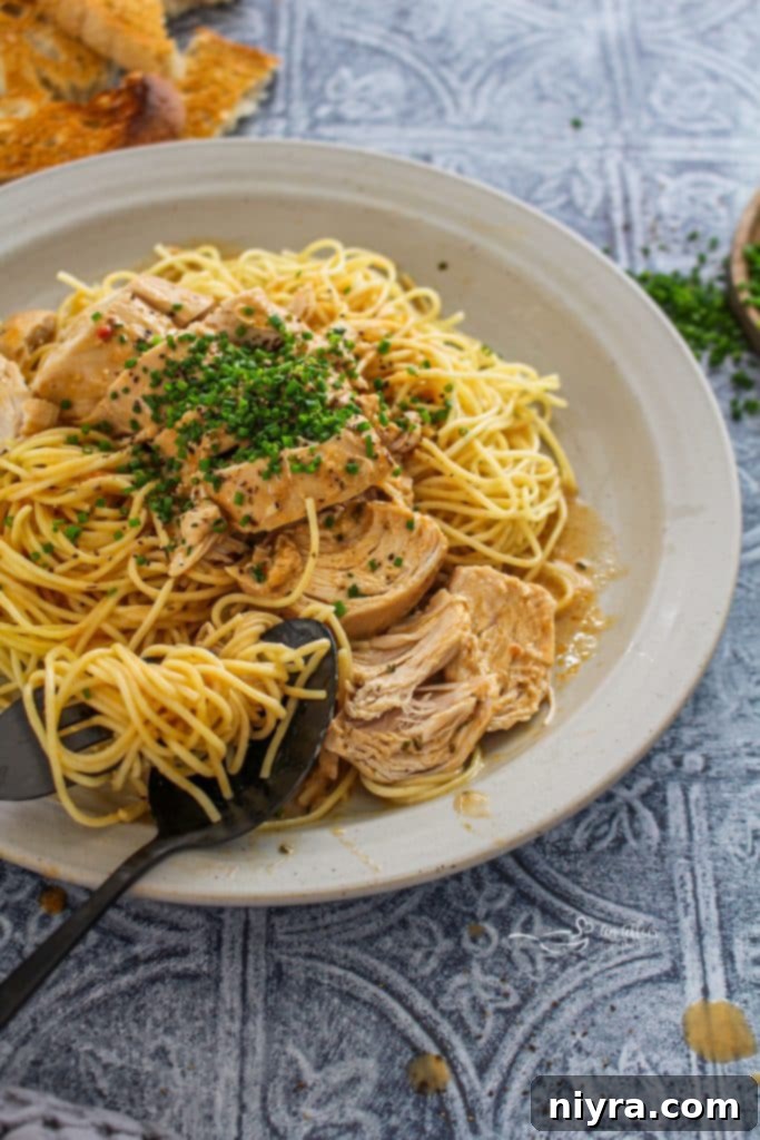 A bowl of creamy Slow Cooker Angel Chicken pasta topped with fresh parsley.
