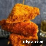 Three Cheese Frenchees stacked on a dark colored plate.