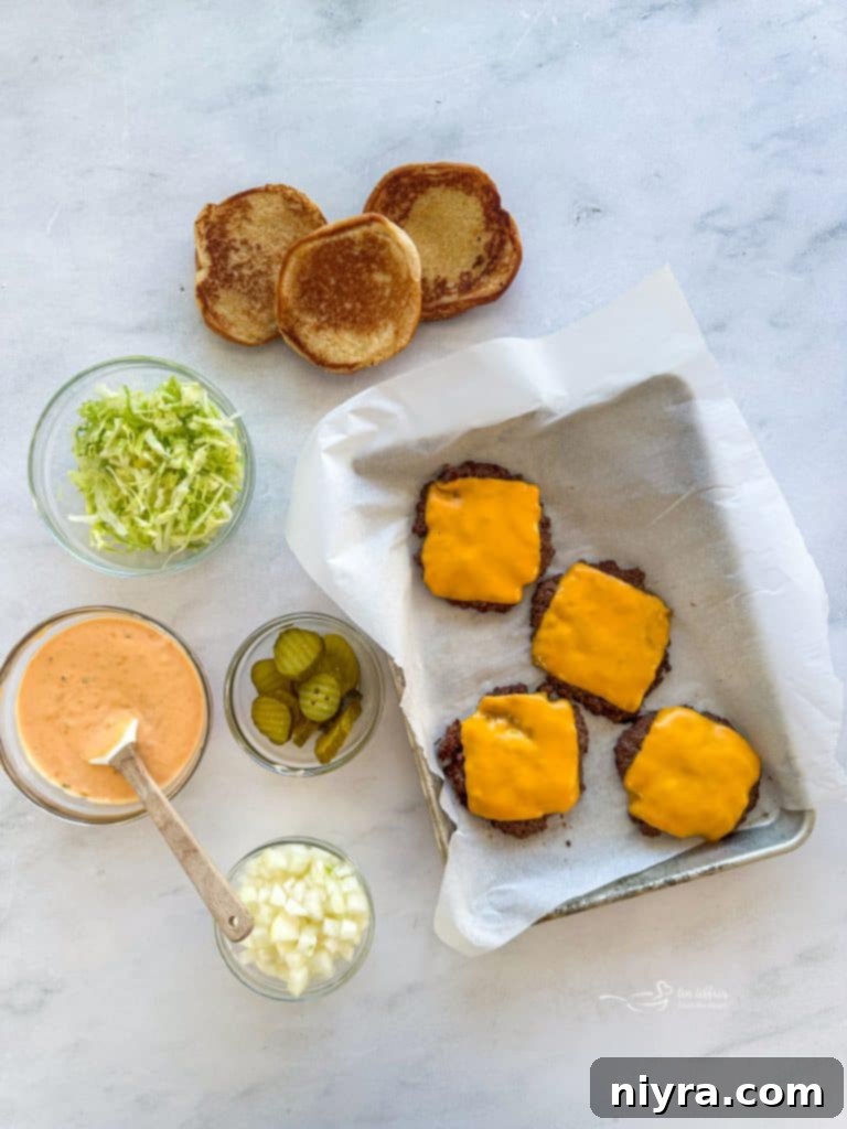 Burger patties cooking in a skillet with cheese melting