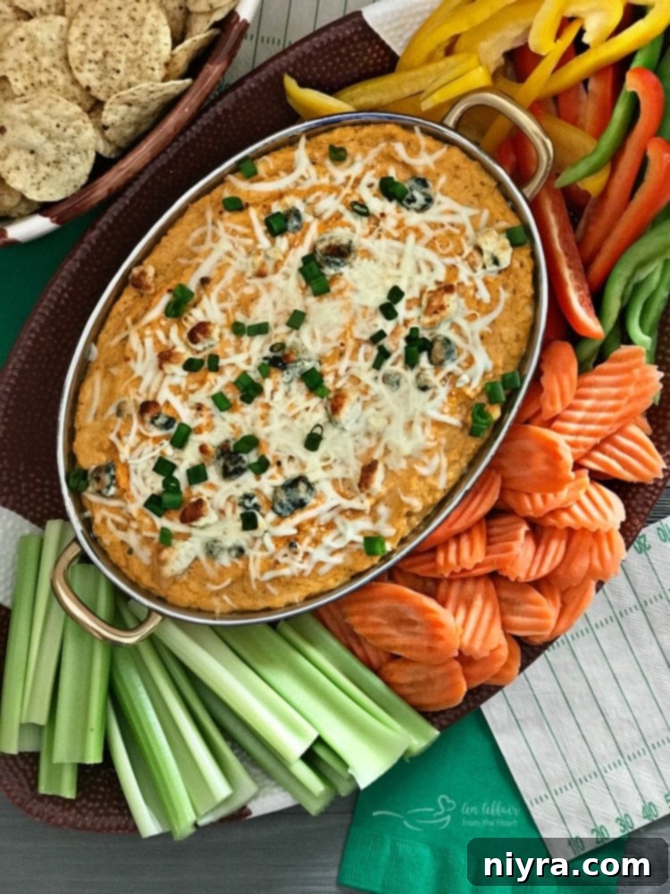 Close-up of a creamy Buffalo Cauliflower Dip, garnished with green onions