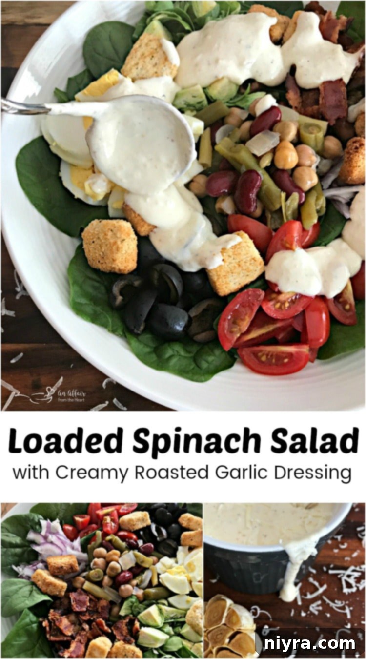 A close-up of a beautifully assembled Loaded Spinach Salad with Creamy Roasted Garlic Dressing, showcasing fresh ingredients like spinach, bacon, beans, and egg.